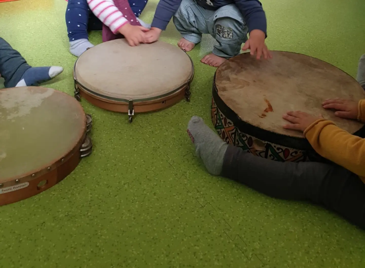 Mains d’enfants jouant sur plusieurs tambours