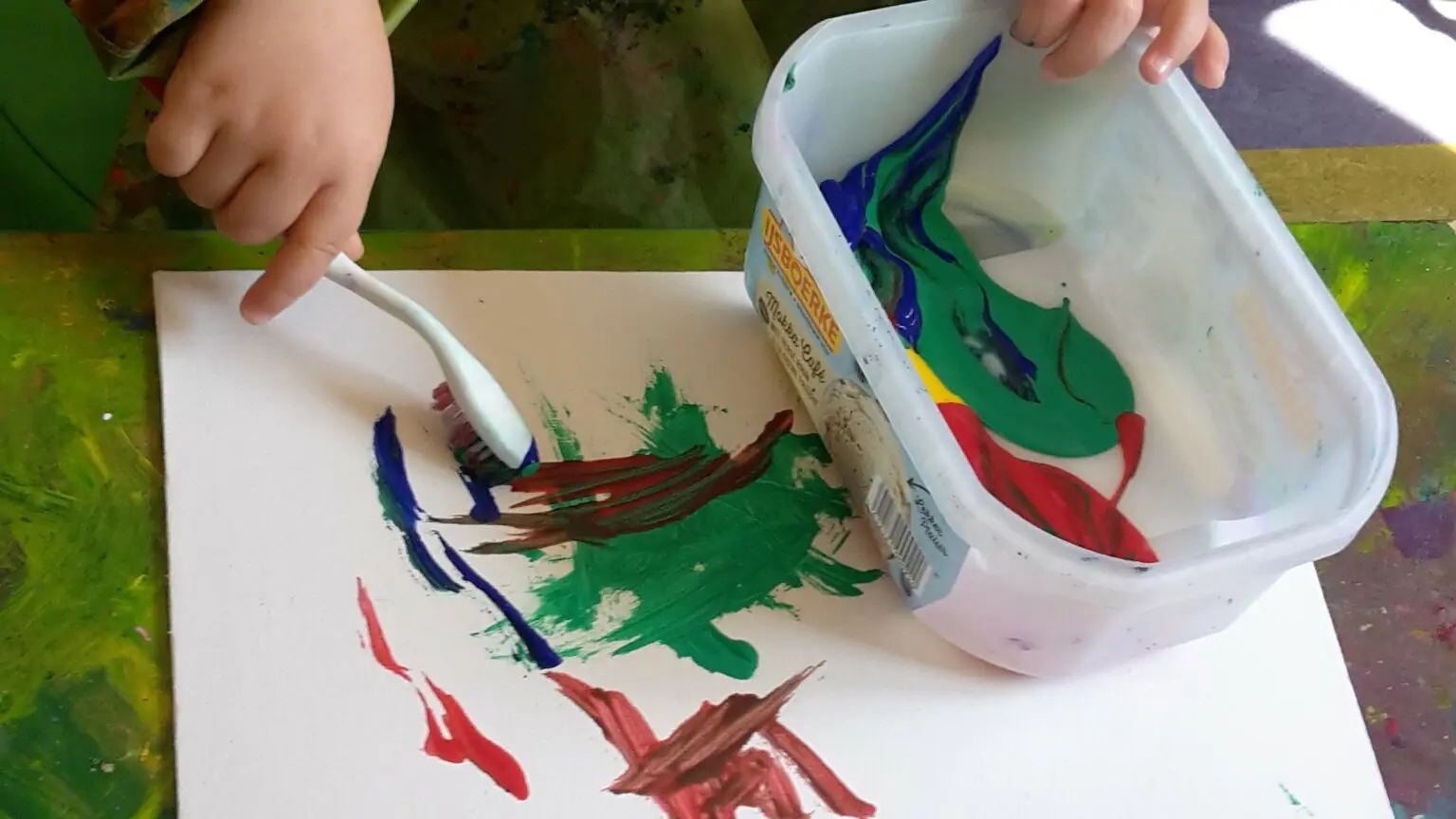 Mains d’un enfant peignant avec une petite brosse